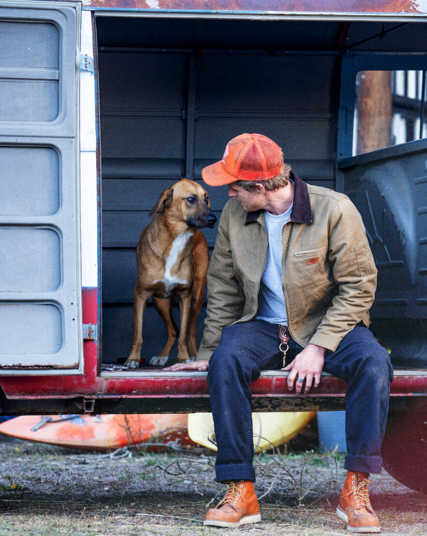 Man sitting on truck with dog
