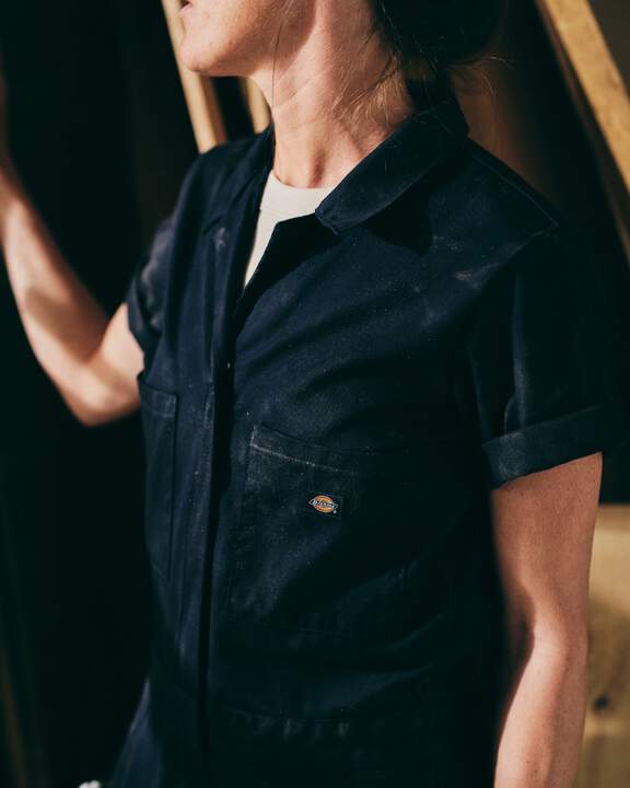 Woman in black shortsleeve coveralls.