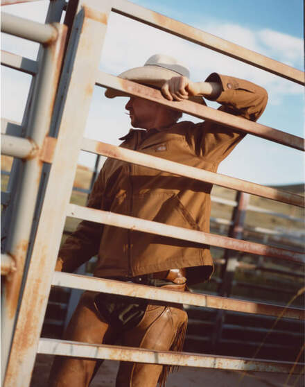 Cowboy leaning on fence