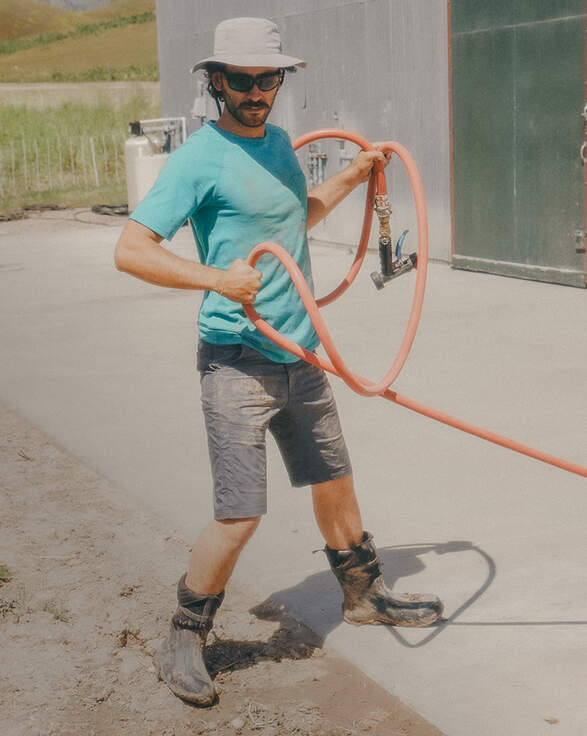 Man in cooling workwear untangling a garden hose