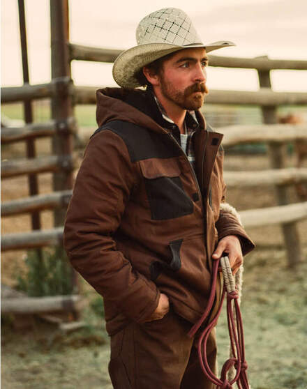 Farmer in cowboy hat holding ropes