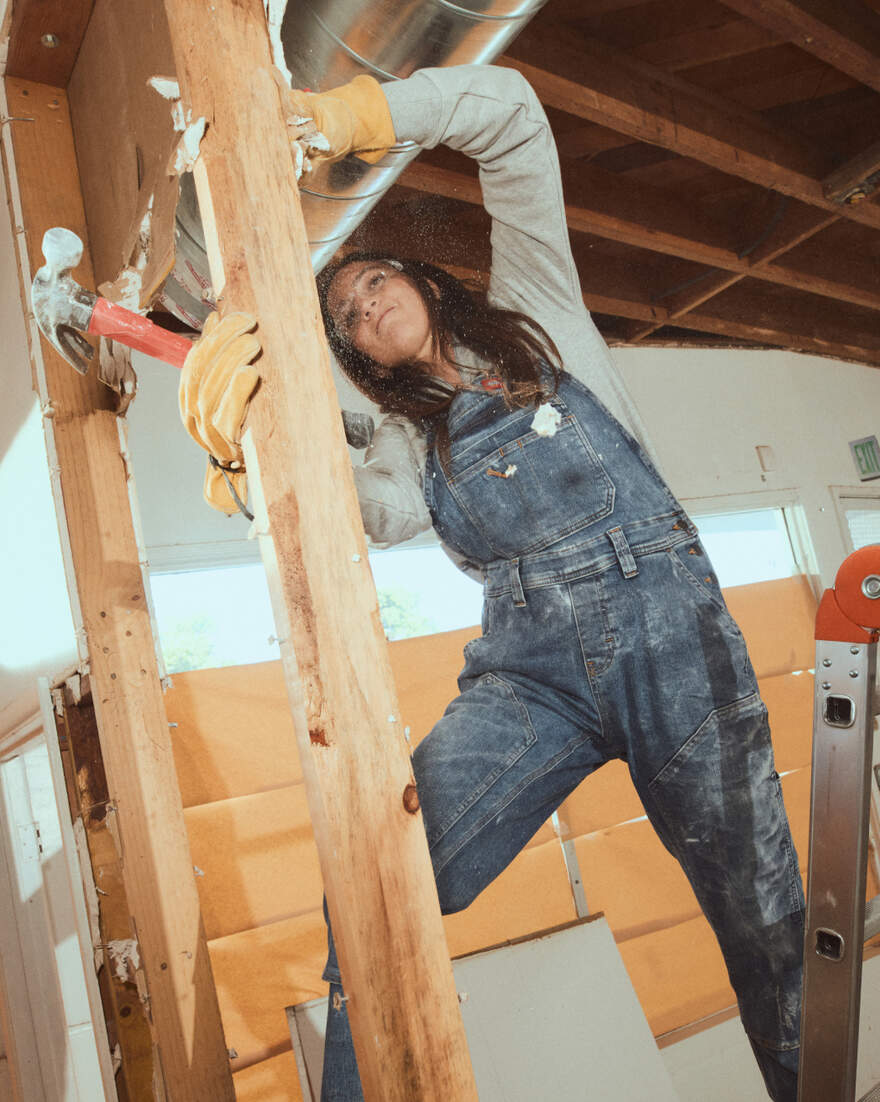 Woman wearing Dickies denim overall while doing framing work