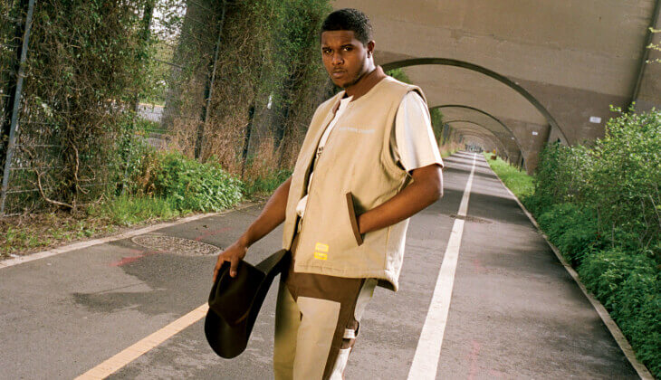 A man standing in the middle of a bike lane outside.