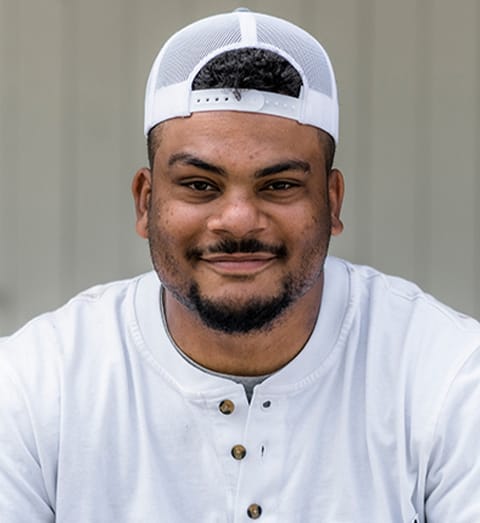 closeup of a man wearing a white shirt and a white cap
