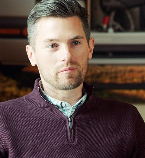 closeup of a man wearing a plum quarter zip sweater