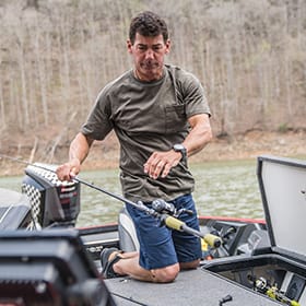 Eric Jackson holding onto a fishing pole in a boat.