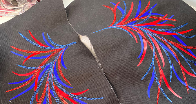 A wireframe of blue and red stitching on black leather.