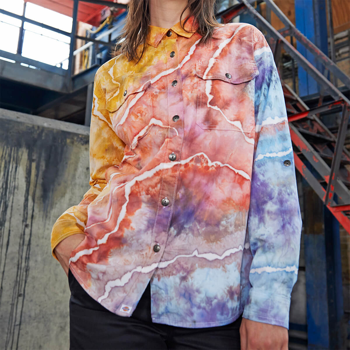 A women's long sleeve shirt altered in a three tone tie-dye color worn on a model.