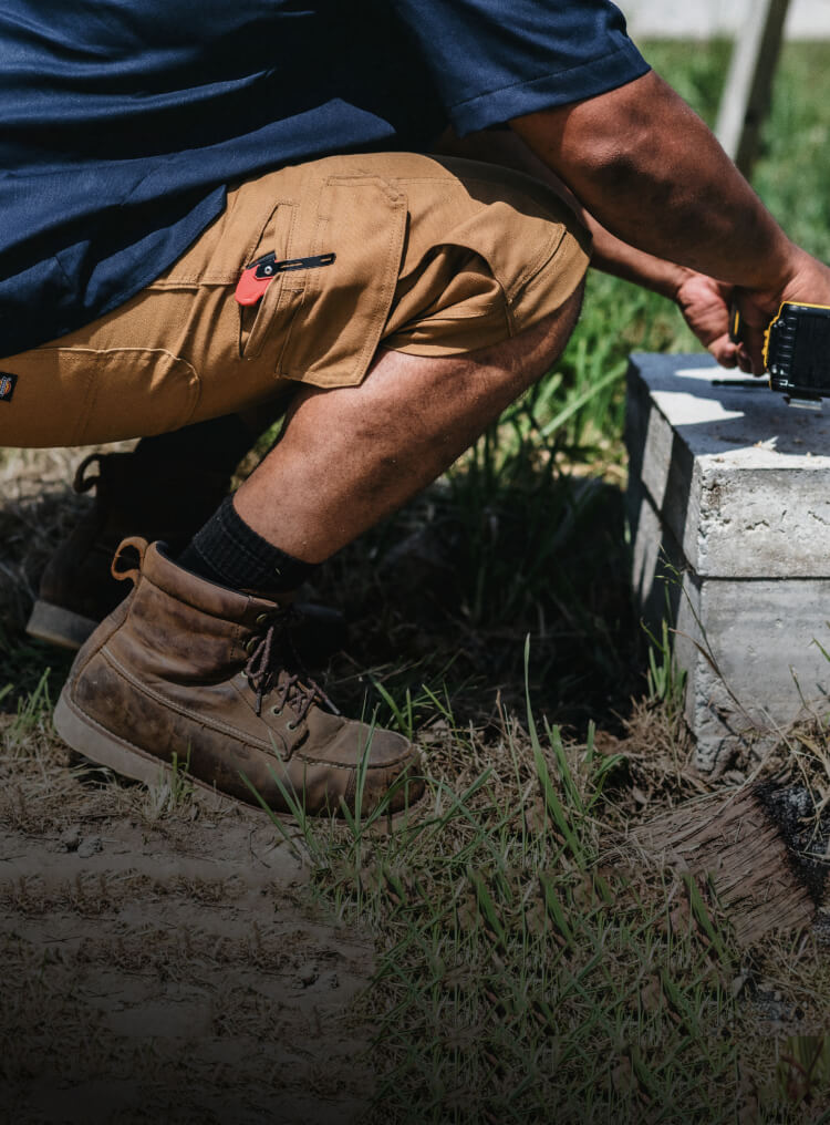 Close up of a man wearing work shorts with tools.