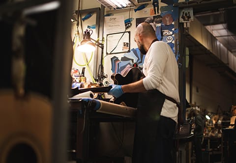 Adam in his work station with a guitar he’s finishing up.