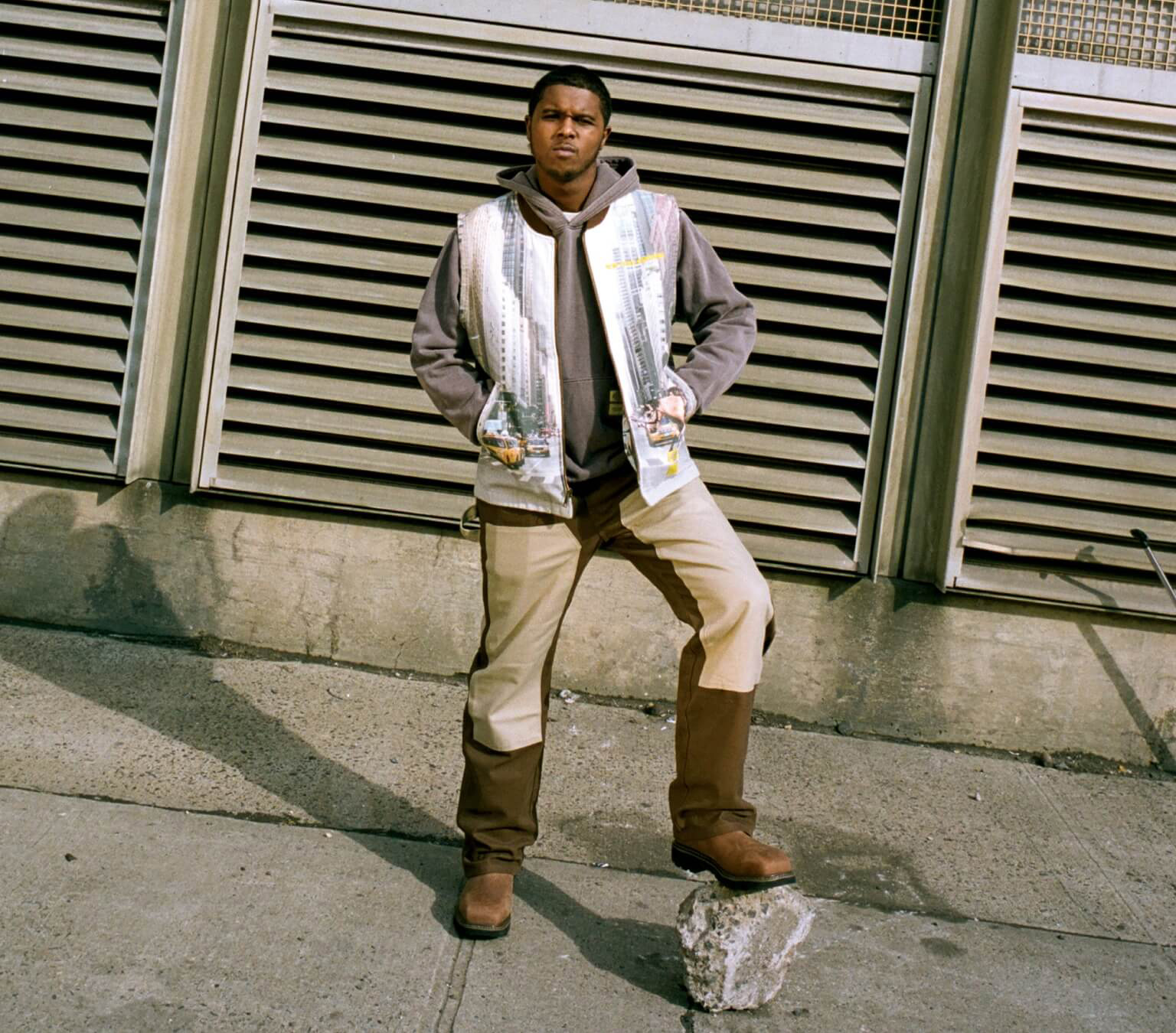 A man standing on a piece of stone on a paved sidwalk