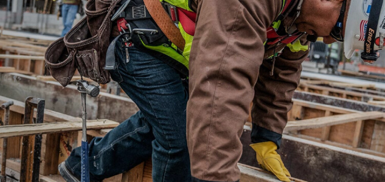 man picking up lumber