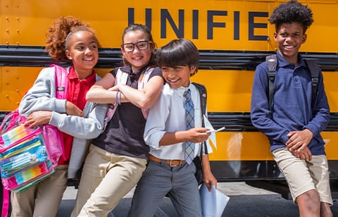 Kids wearing Dickies in front of a school bus