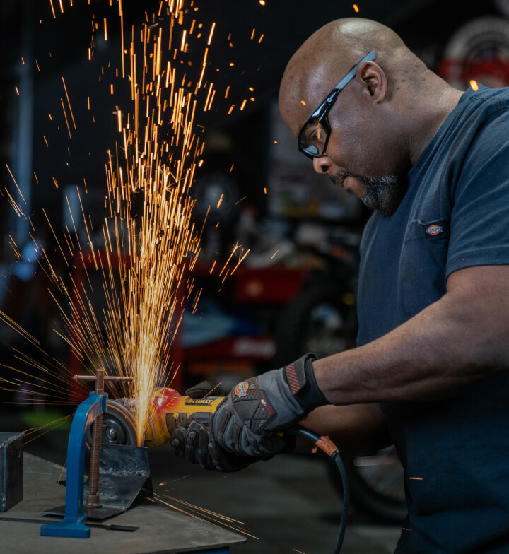 a man using a grinding tool which is making sparks fly upward