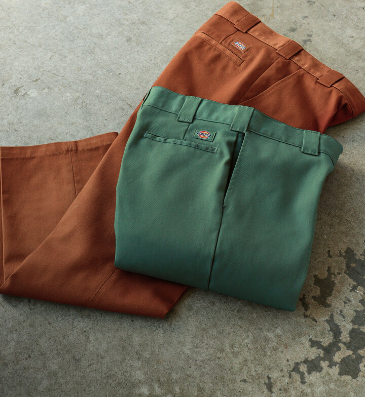 A laydown view of dark ivy 874 pants on top of gingerbread brown 874 pants.