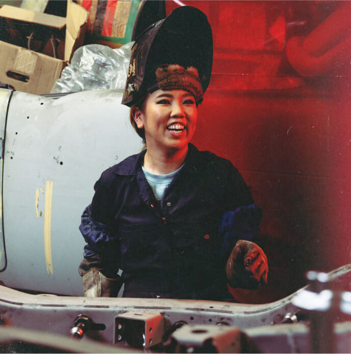 Kay smiling while working on a vehicle.
