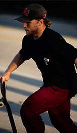man wearing t-shirt while holding a skateboard