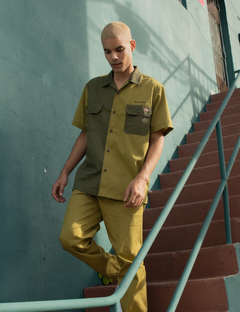 a person walking down stairs wearing a green shirt and pants