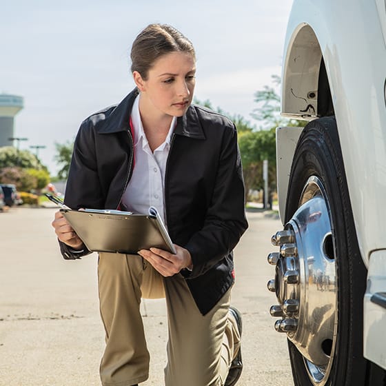Woman inspecting a tire