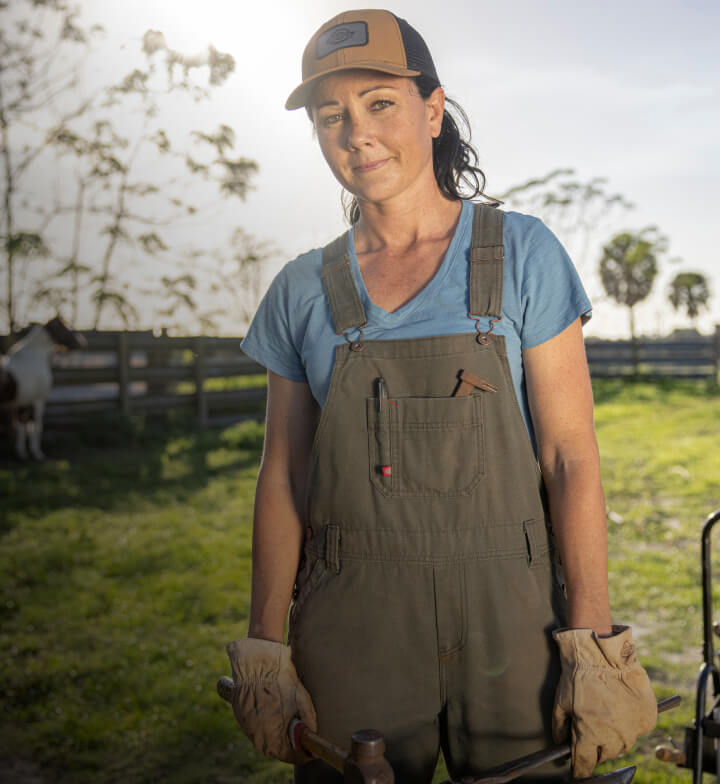 a woman wearing brown bib overalls outside
