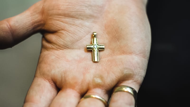 Branden holds a sentimental cross made from for his grandmother out of his grandfather’s wedding band.
