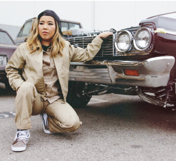 Mechanic Kay Kaoru posing next to a vehicle.