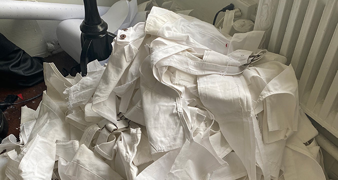 A pile of white fabric clippings on floor.