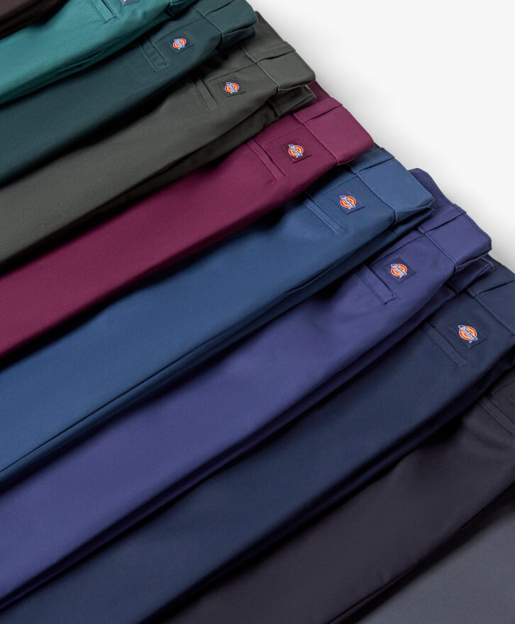 A close-up of different color 874 pants in a line.