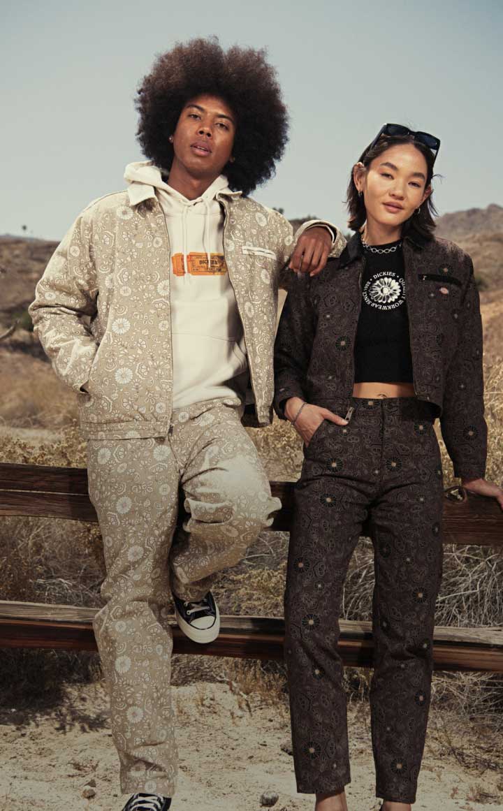 Man and woman leaning against a car wearing denim.